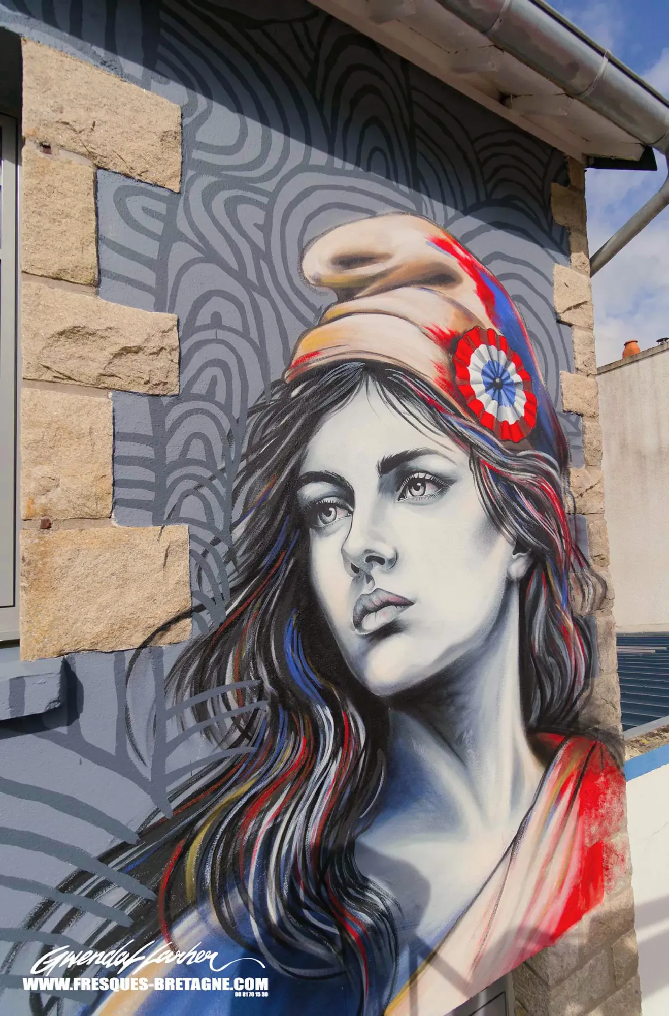 Portrait street art de la Marianne à la cocarde tricolore, fresque murale citoyenne sur le pignon d'une mairie en Bretagne